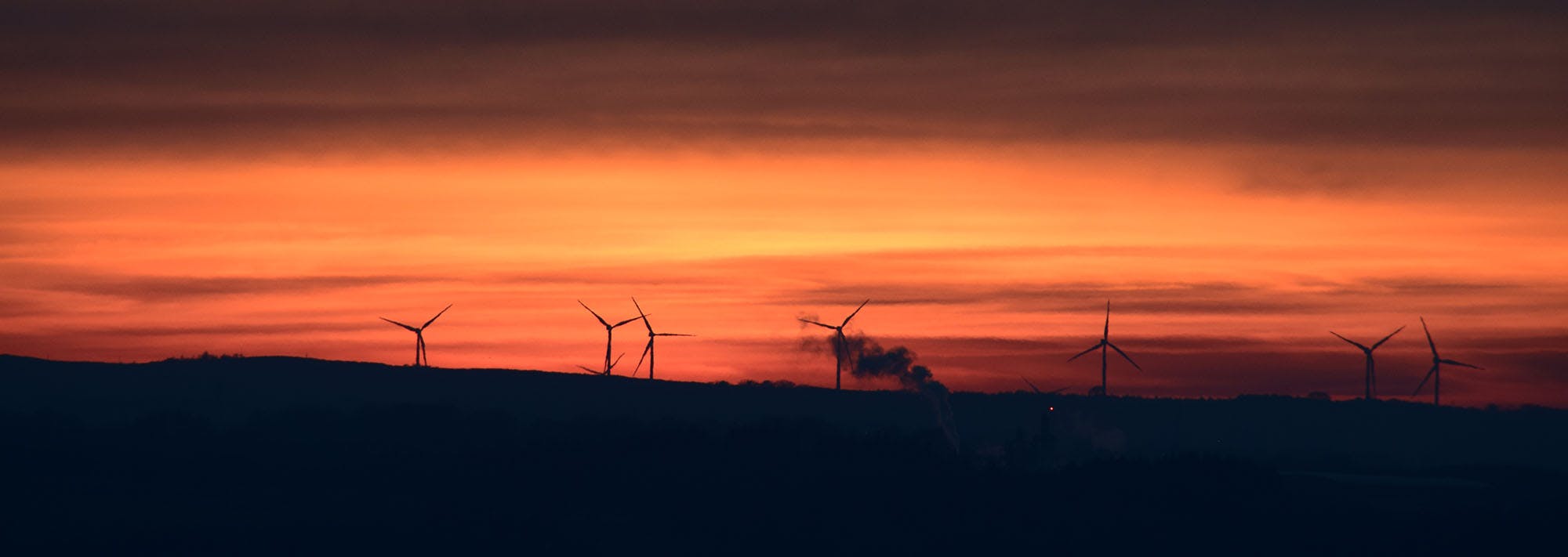 Sunset landscape with wind turbine in background